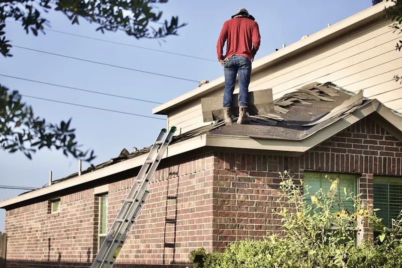 Professional roofer working on a residential roof in South Hanson
